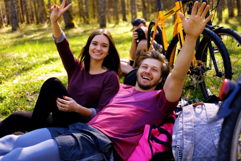 One male and two female relaxing in a park.